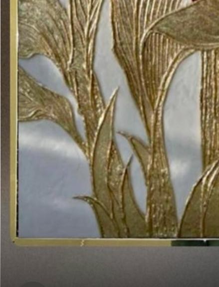 Gold leaf catching light across sculpted texture